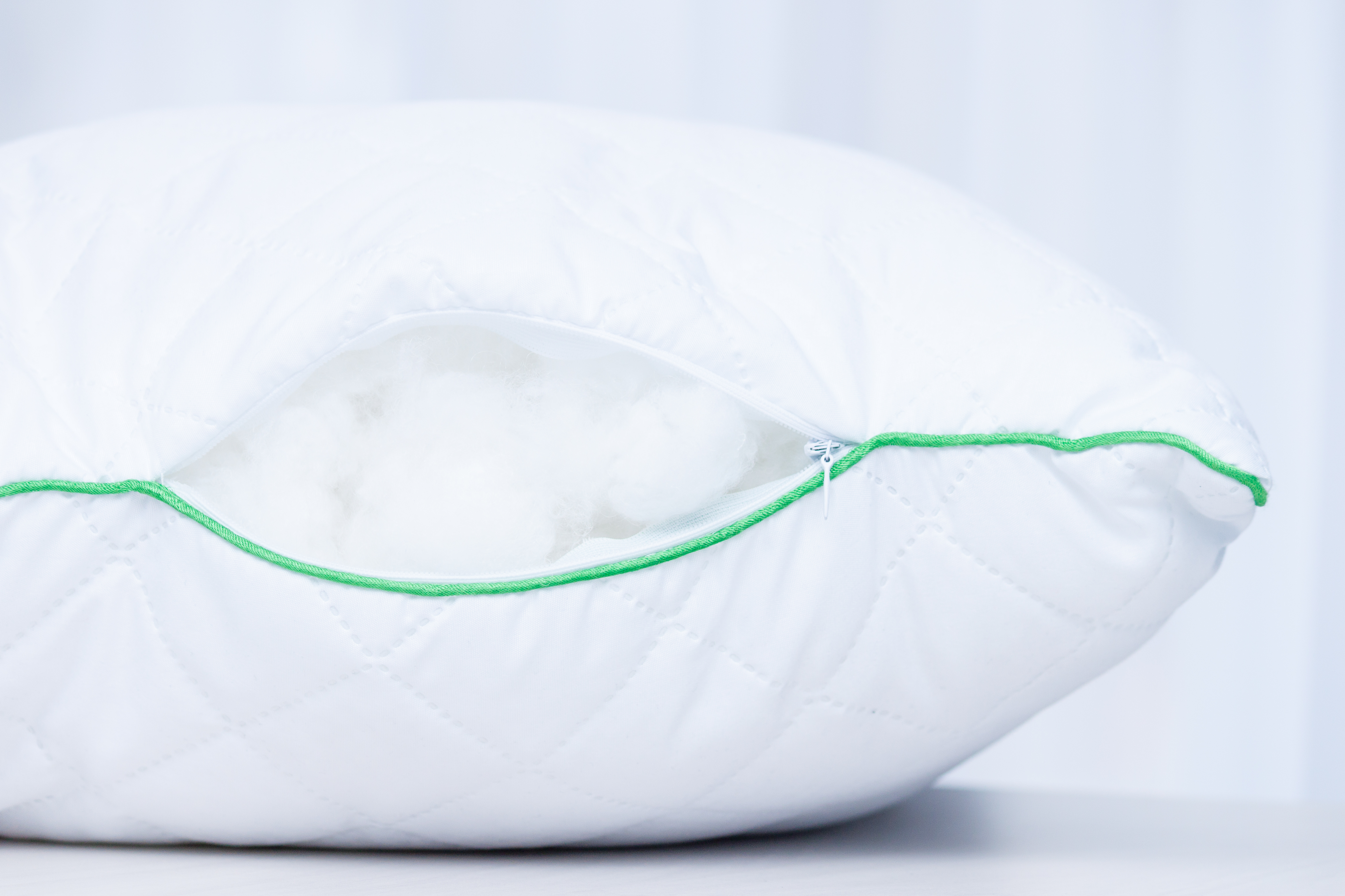 Open white pillow with green piping