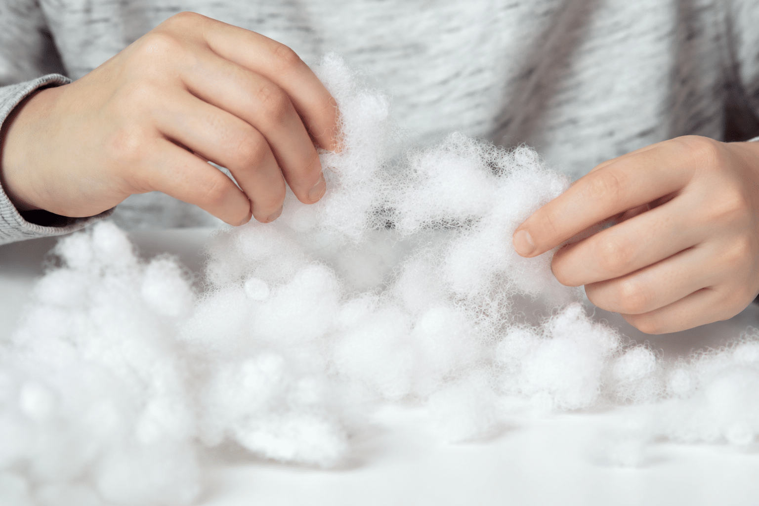 Hands feeling loose white fibers